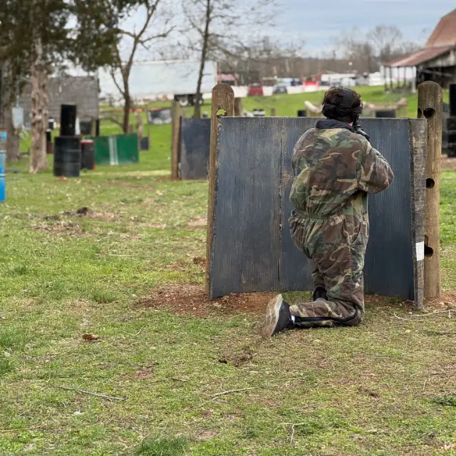 A player kneels behind a wooden barricade on the main field