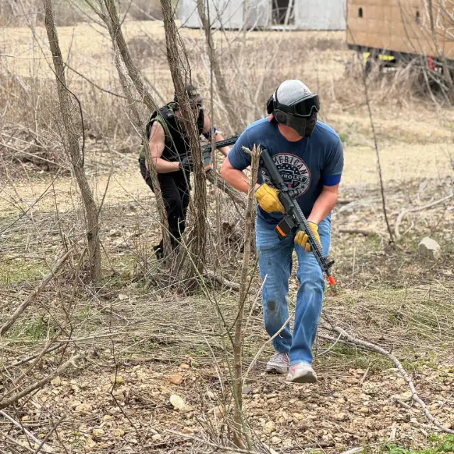 A player in jeans and gloves moves up through the trees