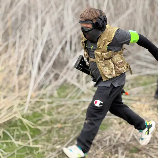 A young player in a plate carrier runs across the field