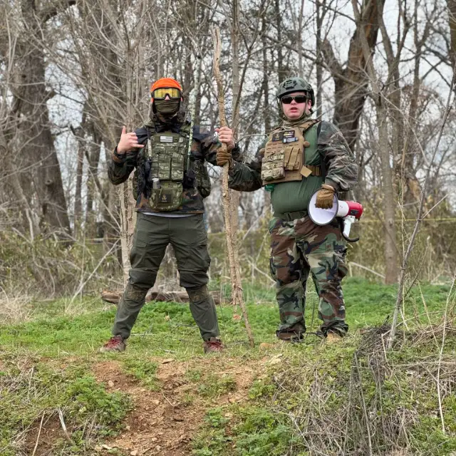 Two players on a hill, one holding a megaphone