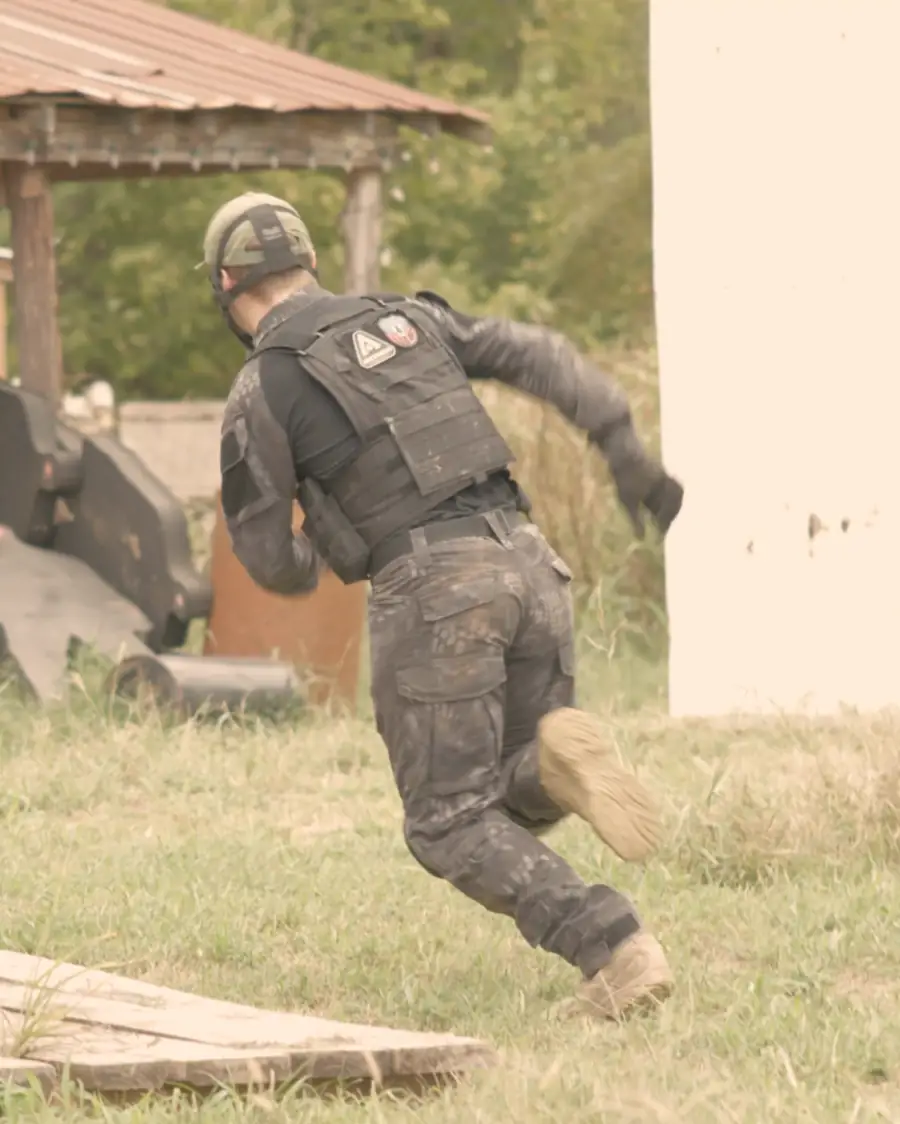 A player in a plate carrier sprints between barricades